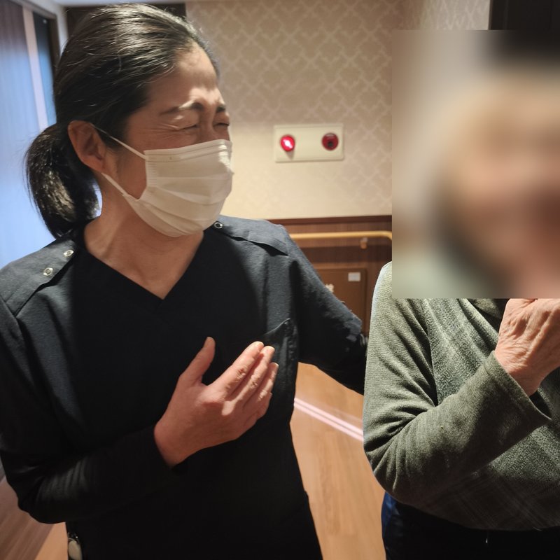 施設の廊下で患者様と笑い合うスタッフ